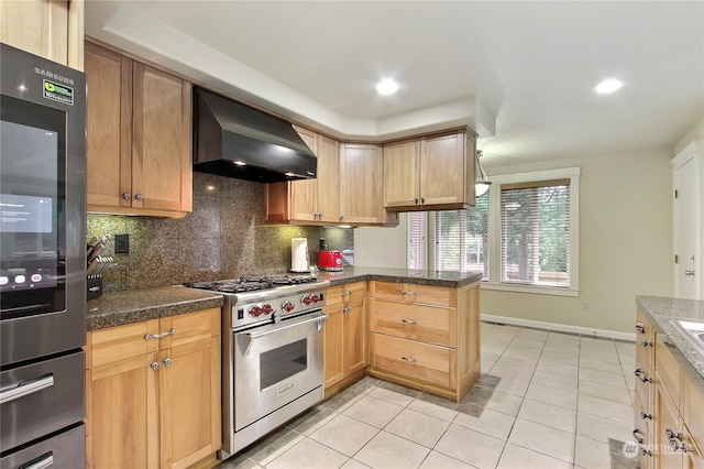 kitchen with premium range, wall chimney range hood, backsplash, kitchen peninsula, and light tile patterned floors