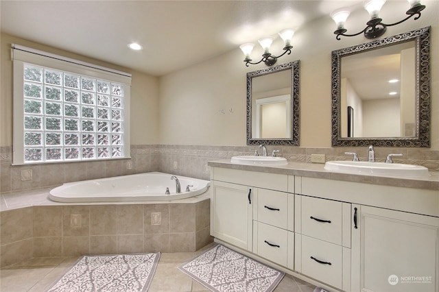 bathroom featuring tile patterned floors, vanity, and tiled bath