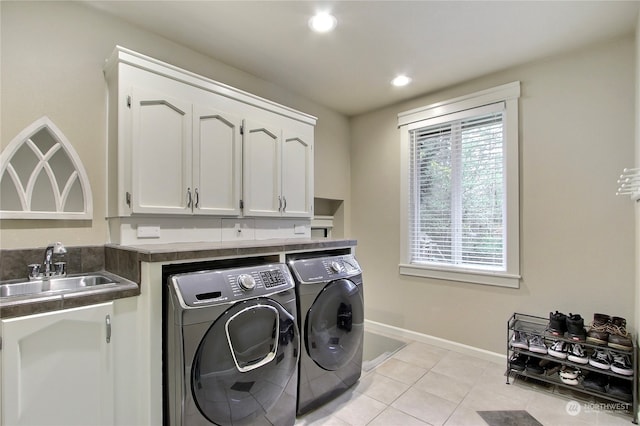 laundry area with sink, light tile patterned floors, and washer and dryer