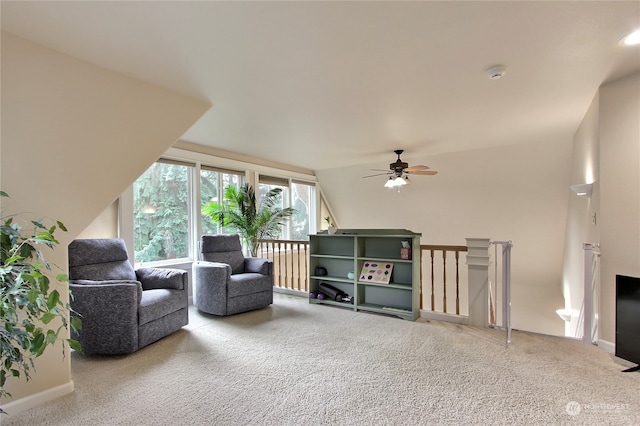 carpeted living room with ceiling fan and vaulted ceiling