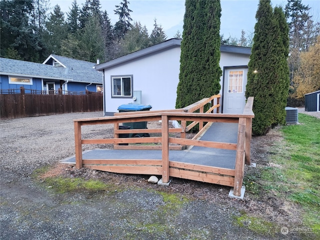 rear view of house featuring a wooden deck and central AC