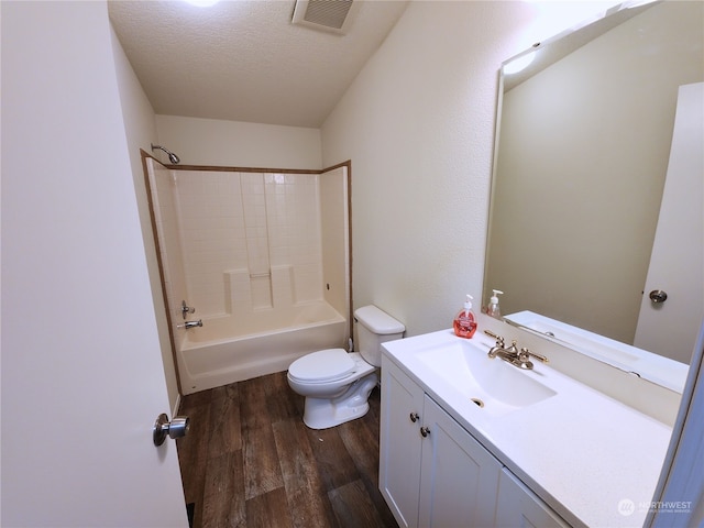 full bathroom featuring hardwood / wood-style floors, vanity, toilet, a textured ceiling, and tub / shower combination