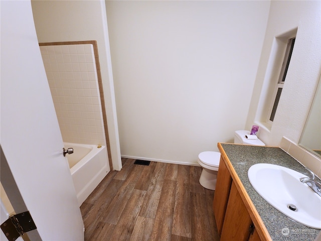 full bathroom featuring hardwood / wood-style floors, vanity, toilet, and bathing tub / shower combination