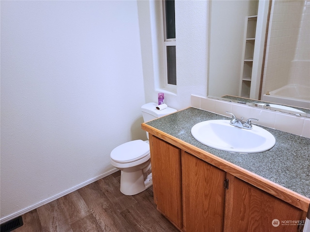 bathroom featuring hardwood / wood-style floors, vanity, toilet, and walk in shower