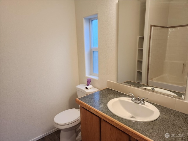 full bathroom with washtub / shower combination, vanity, toilet, and a wealth of natural light