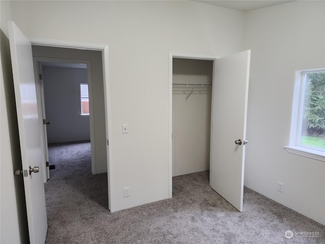 unfurnished bedroom with light colored carpet and a closet