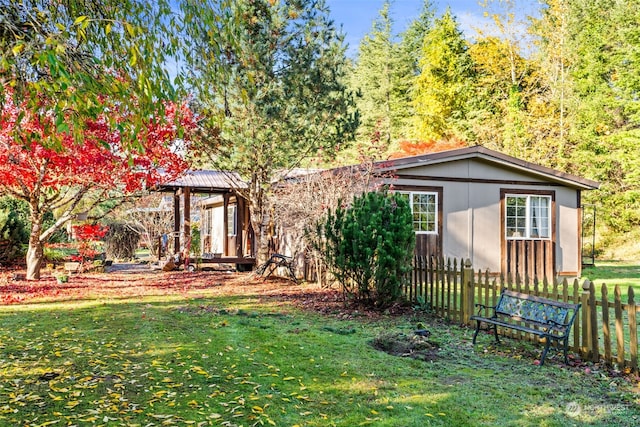 rear view of house with a lawn and a gazebo