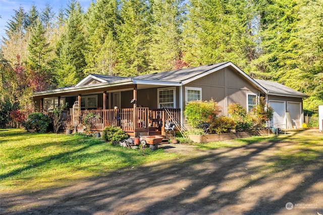 view of front facade featuring a front lawn, a garage, and a porch