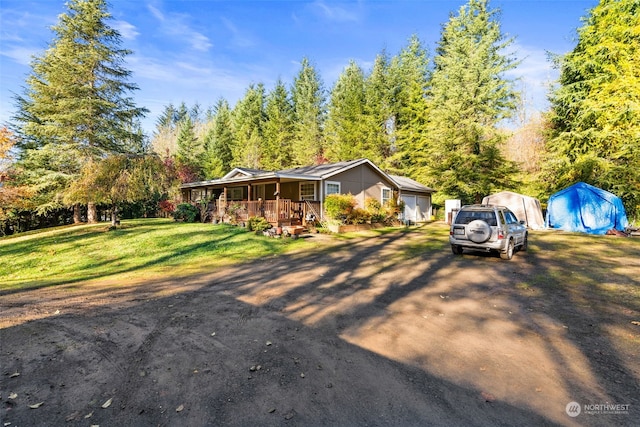 view of front facade with a garage, a front lawn, and covered porch