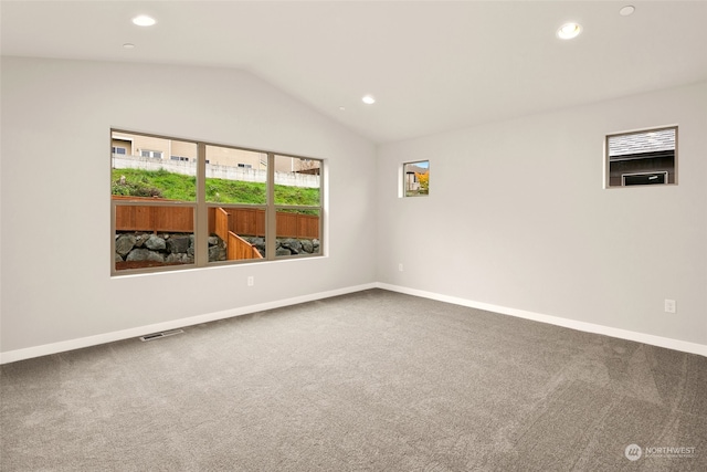 unfurnished room featuring carpet and lofted ceiling