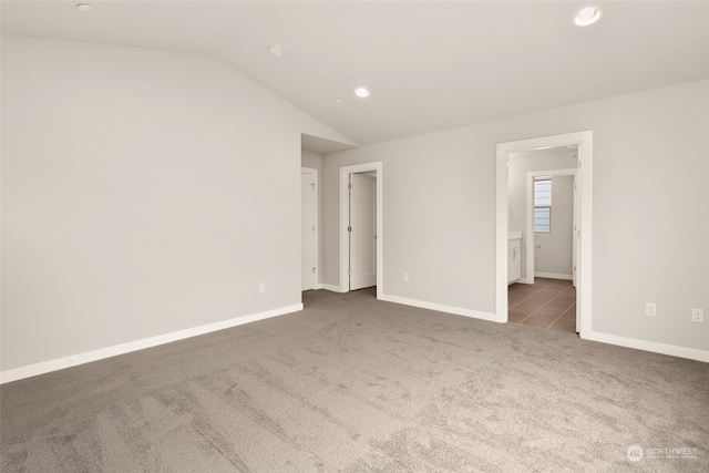 carpeted spare room with lofted ceiling