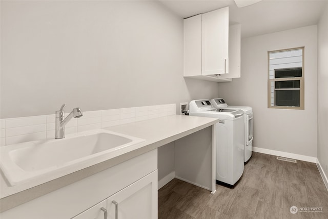 laundry room with cabinets, sink, and washer and clothes dryer