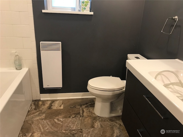 bathroom with toilet, vanity, a tub, and radiator