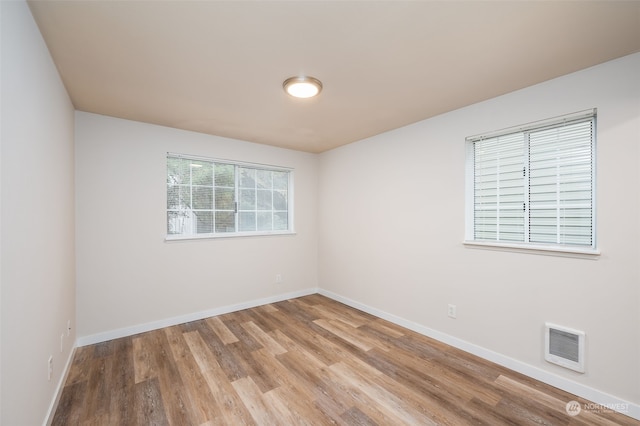 spare room featuring light wood-type flooring and heating unit