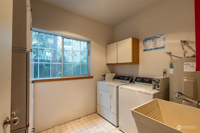 laundry room with cabinets, water heater, sink, and separate washer and dryer