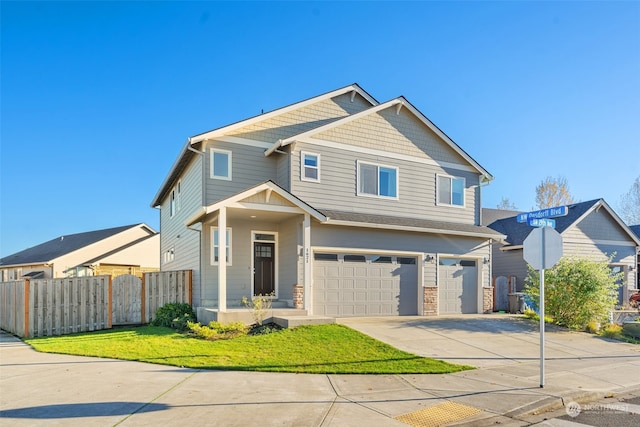 craftsman house with a garage and a front lawn