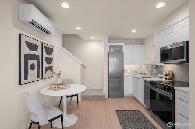 9211C Densmore Ave N, Seattle, WA 98103 - kitchen with appliances with stainless steel finishes, a wall mounted air conditioner, open shelves, white cabinetry, and backsplash