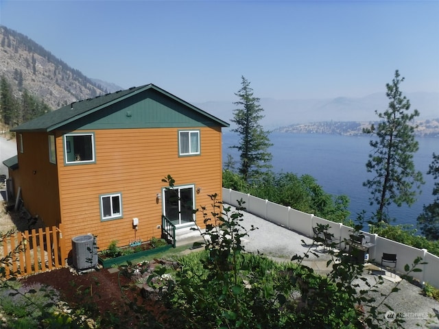 rear view of house with central air condition unit and a water and mountain view