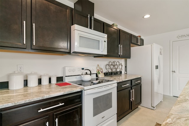 kitchen featuring dark brown cabinetry, light stone countertops, and white appliances