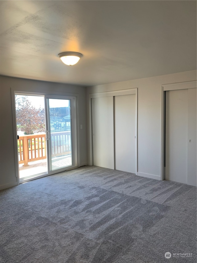 unfurnished bedroom with carpet flooring and access to outside