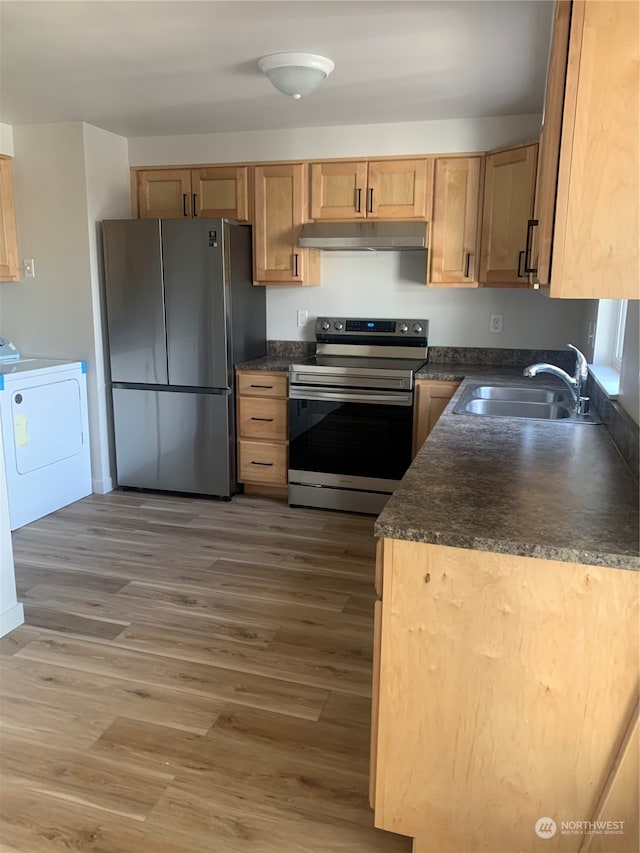 kitchen featuring dark hardwood / wood-style flooring, appliances with stainless steel finishes, sink, and washer / dryer