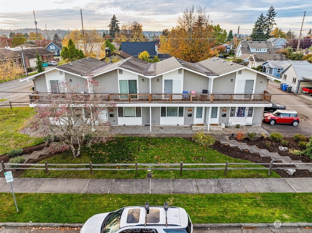 view of front of home with a front lawn and a balcony