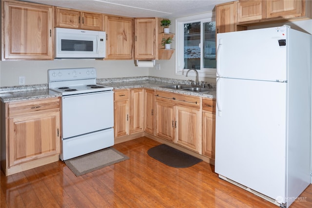 kitchen with a textured ceiling, light brown cabinets, sink, white appliances, and light hardwood / wood-style flooring