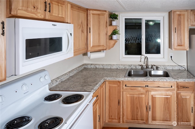 kitchen with a textured ceiling, sink, and white appliances