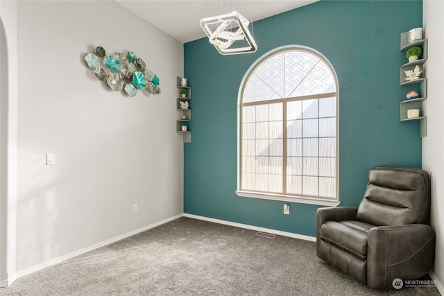 living area with carpet and an inviting chandelier