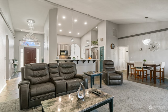 tiled living room with high vaulted ceiling and a notable chandelier