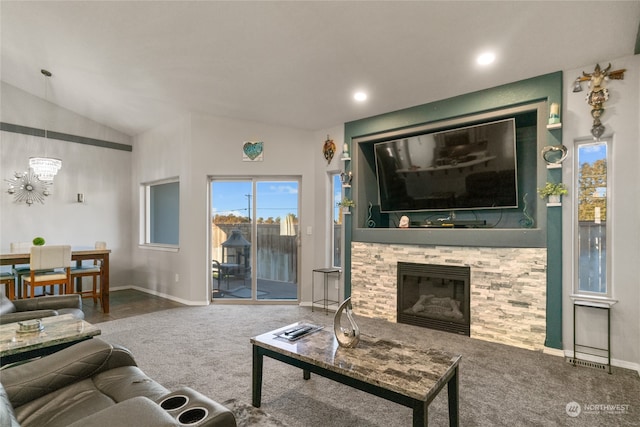 carpeted living room with a stone fireplace and vaulted ceiling