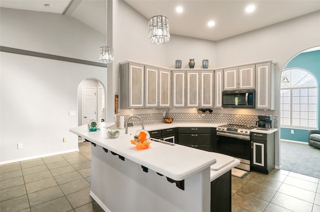 kitchen featuring an inviting chandelier, kitchen peninsula, a breakfast bar area, pendant lighting, and appliances with stainless steel finishes