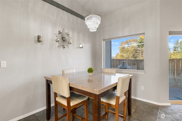 dining area featuring a chandelier, a wealth of natural light, and lofted ceiling