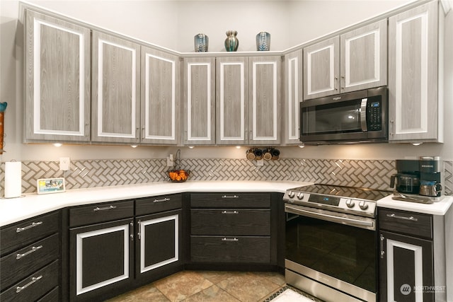 kitchen with tasteful backsplash, appliances with stainless steel finishes, and light tile patterned floors