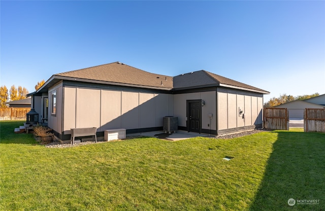 back of property featuring cooling unit and a yard