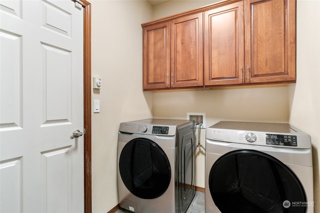 laundry area with cabinets, washer and clothes dryer, and light tile patterned flooring