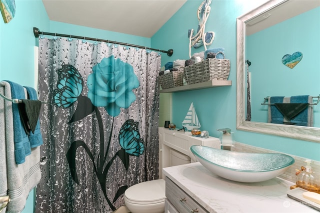 bathroom with curtained shower, vanity, and toilet