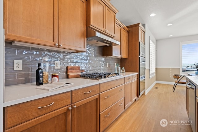 kitchen featuring stainless steel appliances, tasteful backsplash, and light hardwood / wood-style floors