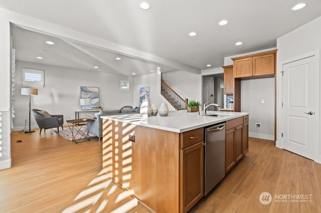 kitchen featuring sink, a center island with sink, dishwasher, and light hardwood / wood-style flooring