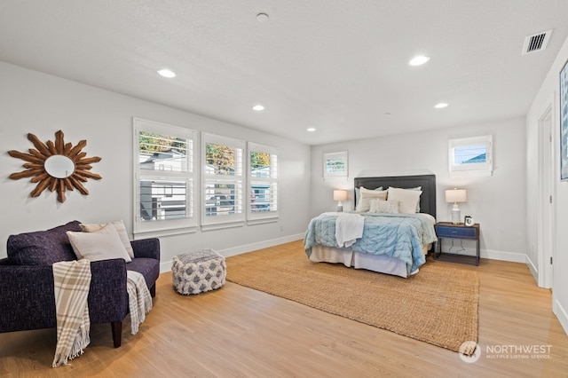 bedroom with wood-type flooring and a textured ceiling