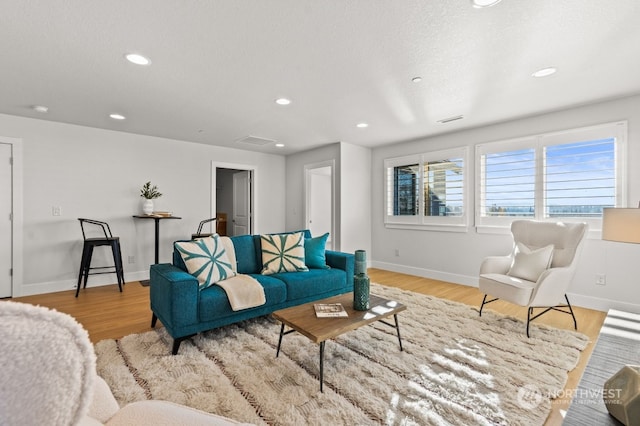 living room featuring a textured ceiling and light wood-type flooring