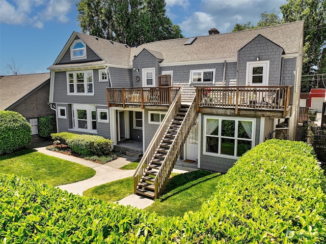 rear view of property with a wooden deck and a yard