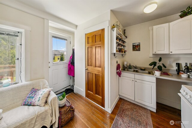 kitchen featuring white cabinets, dark wood-type flooring, sink, and white range oven