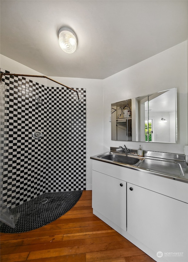 bathroom with walk in shower, wood-type flooring, and vanity