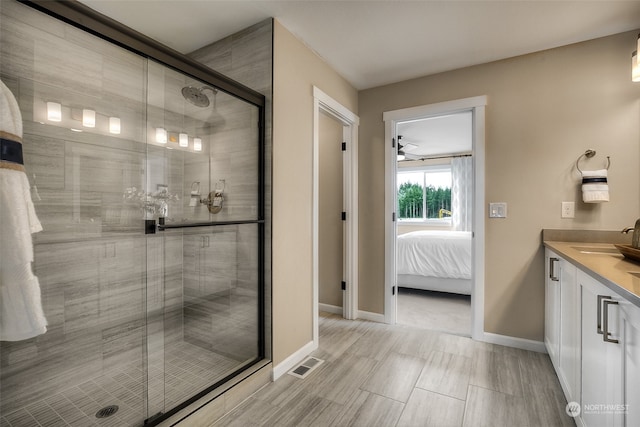 bathroom with ceiling fan, an enclosed shower, and vanity