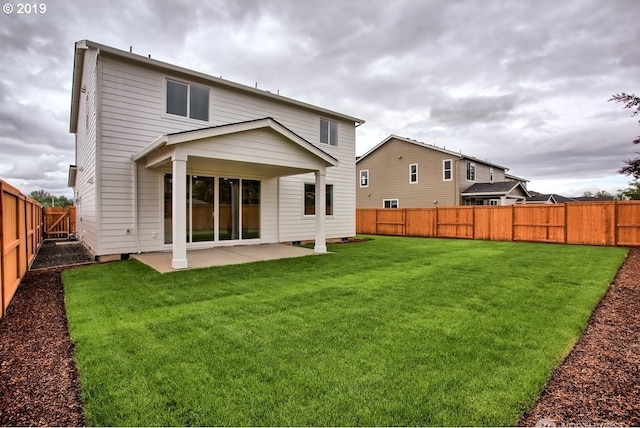 rear view of house featuring a lawn and a patio