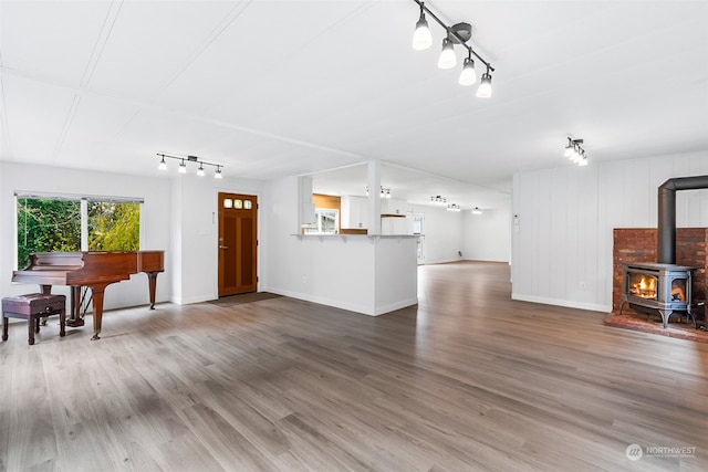 living room featuring wood-type flooring and a wood stove