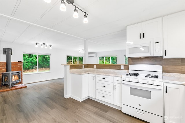 kitchen with white appliances, a wealth of natural light, and white cabinets