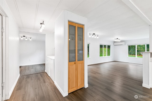 hall featuring track lighting, dark hardwood / wood-style floors, and an AC wall unit