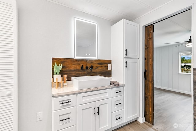 interior space with vanity, hardwood / wood-style floors, and ceiling fan